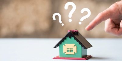 Do houses sell for less at auction? Image of a model house with question marks