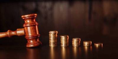 Image of an auction gavel with coins.