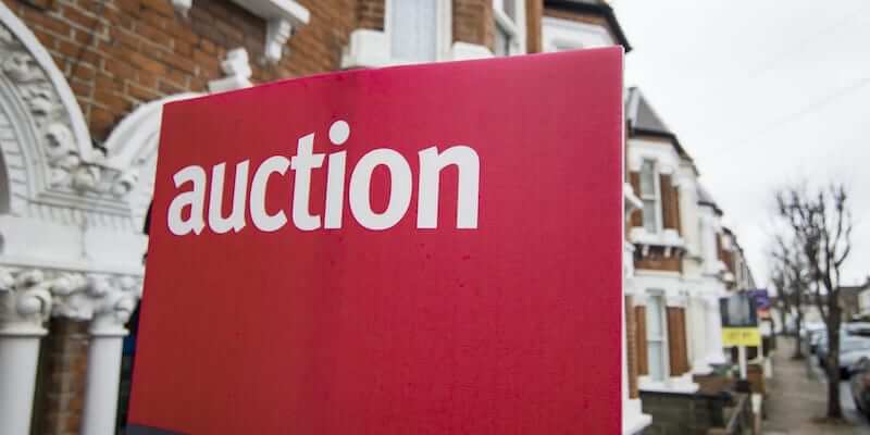 Image of an auction "for sale" board outside a property