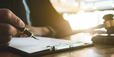 Image of a lawyer and a gavel. Buying property at auction is serious business, and you face legal consequences if you can't complete afterwards.
