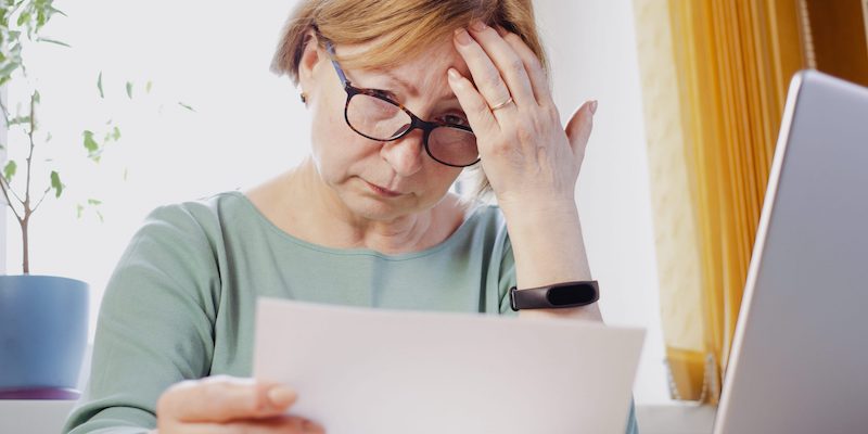 Lady reviewing expensive bills.