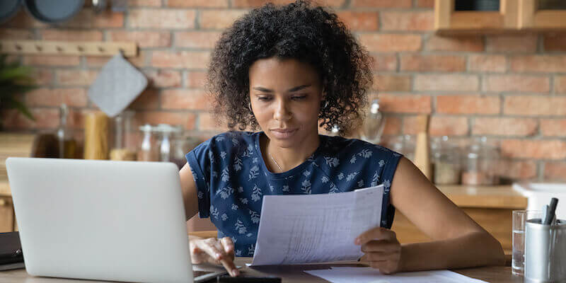 Calculating capital gains tax (CGT) on inherited property - lady with laptop and calculator