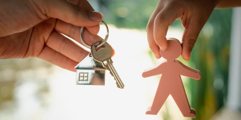 What To Do If You Inherit a House With Tenants. Child holding a model of a person and dad holding house keys and house keyring.