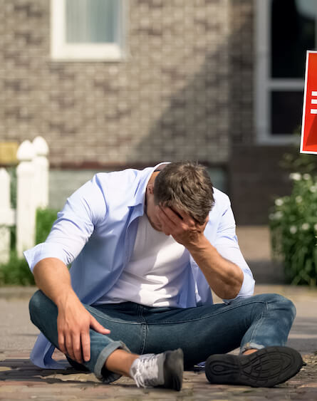 Frustrated man sat on the floor after making a mistake at auction