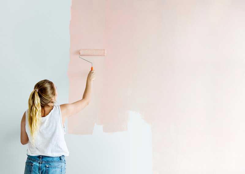 A lady painting an inherited house ready for selling.