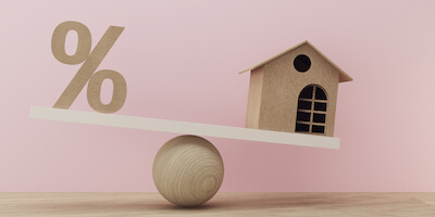 What percentage of house sales fall through? Seesaw with a percentage sign and wooden house balancing. 