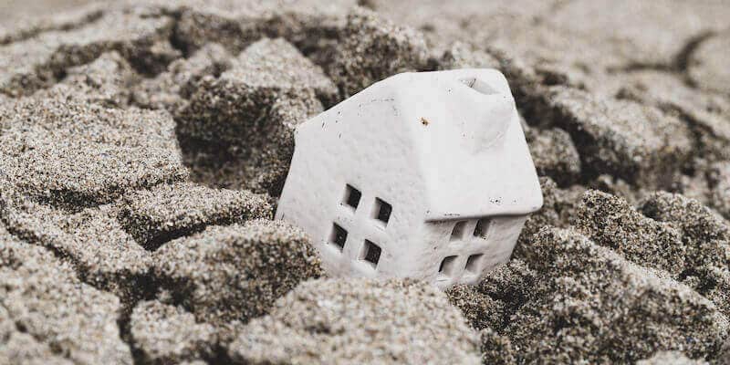 Can you sell a house with subsidence. Toy house sinking and subsiding into ground.