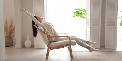 Image of a happy lady leaning back in a chair after using a house buying company to repair a broken house chain
