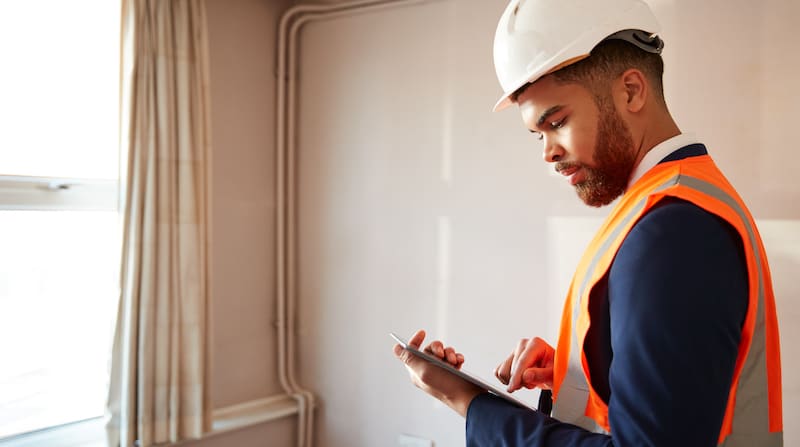 Picture of a man doing a survey on a house.