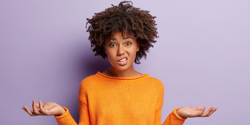 A picture of a confused woman on a purple background. Wates houses complete guide, top 9 most popular FAQs. 