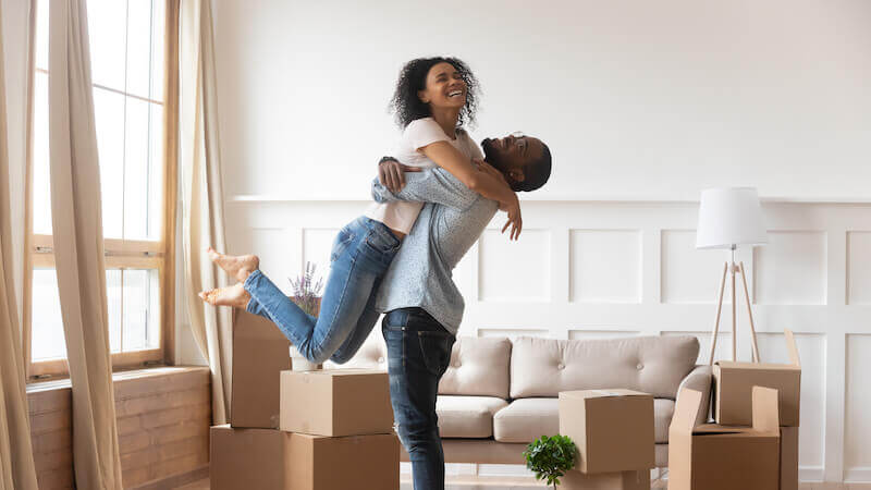 A couple looking overjoyed after selling their house and moving into dream home.