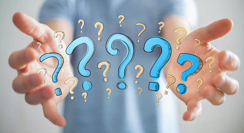 A man holding question marks.