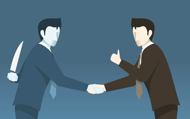 A cartoon of a man shaking hands with another man holding a knife behind his back.