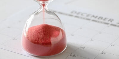 Hourglass sat on top of calendar. How long does it take to sell a house at auction?