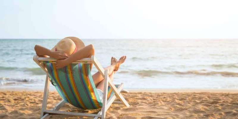 Lady relaxing on a beach - she's in control of her house sale! 