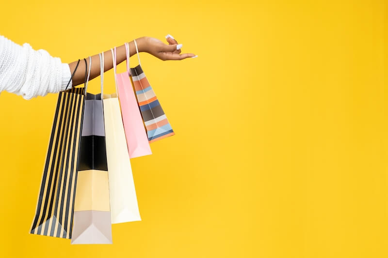 A lady holding five shopping bags.